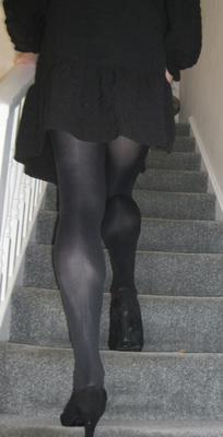 Schwarze blickdichte Strumpfhose, schwarzes Kleid und High Heels